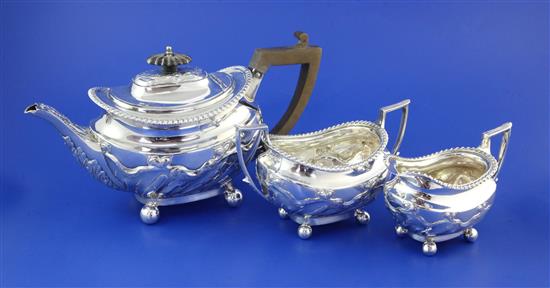 A late Victorian repousse silver three piece tea set, gross 27 oz.